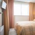 Studio's De Vlijt Texel in De Cocksdorp: cozy double bed room with window, curtains, and wall-mounted TV