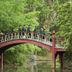 Williamsburg Manor B&B bridge over a creek in a lush wooded garden with guests standing on it