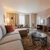 Hilton Garden Inn Sioux Falls Downtown living room with TV wall, sofa, coffee table and striped rug