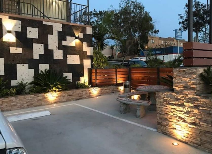 Berkshire Motor Hotel San Diego courtyard with stone benches, potted plants, and exterior lighting