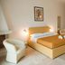 Agriturismo I Pozzetti in Fasano: double bed, armchair and bathroom doorway in a guest room