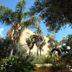Hotel della Valle in Agrigento, lush garden with palm trees and a yellow hotel building under blue sky