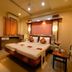Hotel NavaRATNA, Coimbatore: double bed guest room with desk, chair, and warm lighting