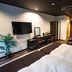 Livemax Resort Hakone Ashinoko room with bed, wall TV, desk, and recliner chair in Hakone