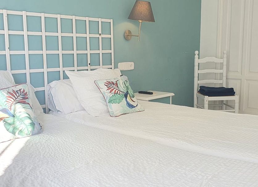 Hugo Beach Hotel & Apartments in Gandia, twin beds with teal wall and white headboard