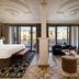 BLESS Hotel Madrid luxury suite with king bed, seating area, and balcony city view