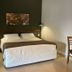 Hotel Fazenda Areia que Canta bedroom in Brotas with king bed, bedside lamps, and small dining table