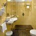 Danubius Health Spa Resort Nove Lazne bathroom with shower, wall sink, and tiled floor in Mariánské Lázně