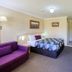 Cootamundra Gardens Motel room in Cootamundra with queen bed, sofa, desk and wall-mounted TV