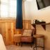 The Wiremill in Lingfield room with wall-mounted TV, desk shelf, chair and window blinds