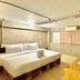 The Yak Cozy Chiang Mai room with a double bed, desk, and curtained window in Chiang Mai