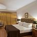 Golden Tulip Porto Gaia guest room in Vila Nova de Gaia with king bed, armchair, desk and wall-mounted TV