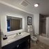 Independence Stay Hotel and Long term suites in Houghton bathroom with vanity, toilet, and tub-shower combo