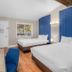 The Inn at Boatworks, Lake Tahoe room with two beds, blue accent wall and Tahoe City window view