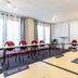 Campanile Mulhouse Sud - Morschwiller meeting room with tables, red chairs, and projector screen in Mulhouse
