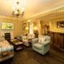 Rokeby Manor, Invergarry lounge with floral sofas, chandelier, wood flooring and fireplace