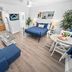 Beachside Gardens Apartments By Lowkl in Deerfield Beach room with blue sofa, bed, and kitchenette