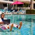 Hotel Adeline, Scottsdale poolside scene with a guest on a float working on a laptop