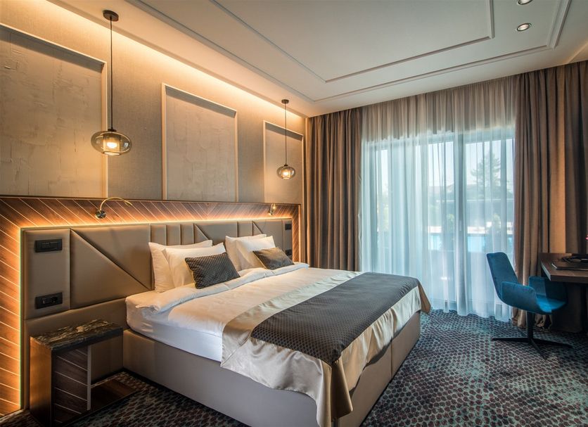 Sky Blue Hotel & Spa Ploieşti room with king bed, desk, and floor-to-ceiling window