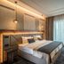 Sky Blue Hotel & Spa Ploieşti room with king bed, desk, and floor-to-ceiling window