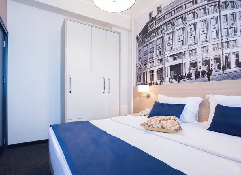 Five Points Square - City Center Belgrade guest room with blue accents and a large black-and-white city mural