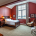 The Inn At Cobble Beach guest room in Balmy Beach with red walls, wood bed and large window view