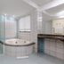 Hotel Plaza Camboriú bathroom with glass shower, corner bathtub and tiled vanity in Balneário Camboriú