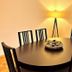 Hotel Friedrichstraße in Lampertheim dining area with oval table, chairs, and floor lamp by window