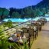 Outdoor terrace dining at Kaya Izmir Thermal & Convention in Izmir beside a lit pool and hillside view