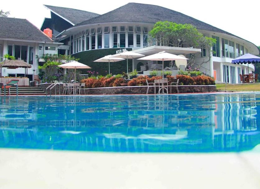 Concordia Hotel Bumi Sangkuriang Bandung poolside terrace with umbrellas and white chairs