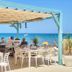 Hotel Noguera Mar in Denia with beachfront dining tables and sea view under a shaded pergola