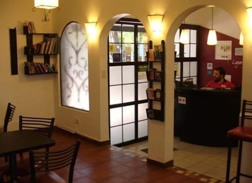 Hostel Lagares in Mendoza lobby with arched doorway, reception desk, seating area and warm wall lights