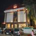 Hotel Naivedya in Aurangabad at night, with lit facade, parked cars and palm trees