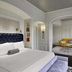 The Adelphi Hotel in Saratoga Springs guest room with king bed, sitting area and tufted blue headboard
