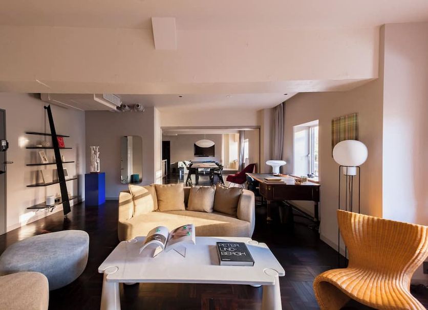 The Knot Tokyo Shinjuku suite with seating area, desk, and city-view windows in Tokyo