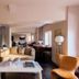 The Knot Tokyo Shinjuku suite with seating area, desk, and city-view windows in Tokyo