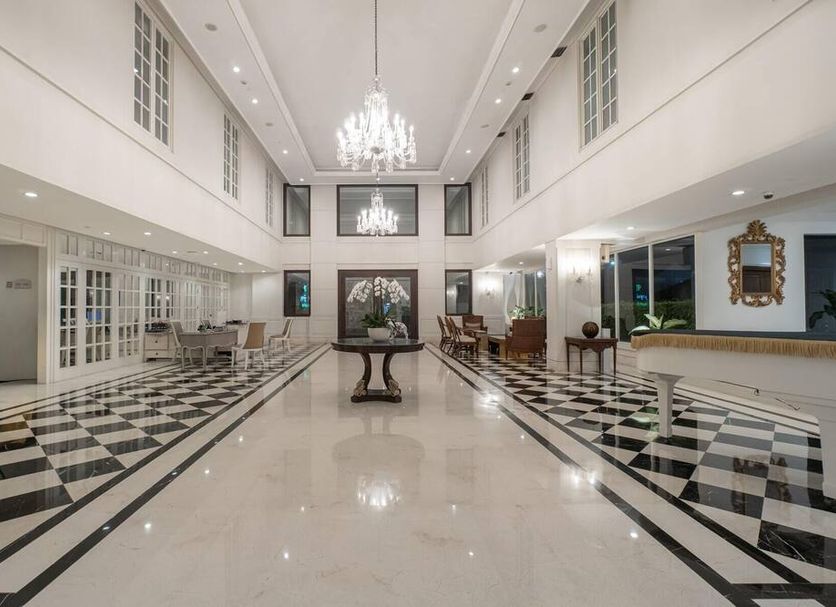 Nims Hotel Seminyak in Kuta lobby with chandeliers, checkered tile floors, and seating area
