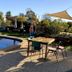 Kingswood Motel in Tocumwal features a poolside outdoor seating area beside a blue swimming pool.