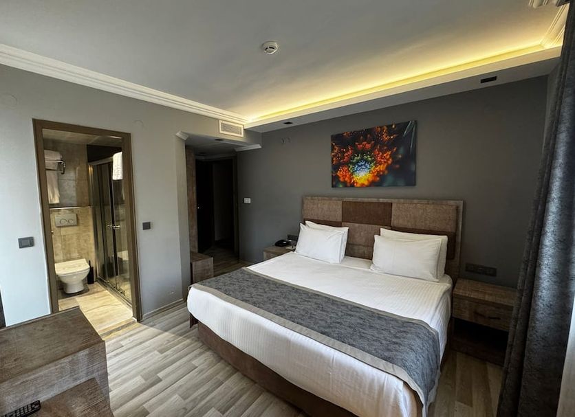 Ankara Royal Hotel guest room in Ankara with a double bed, bedside tables and a private bathroom doorway