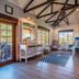 Gondwana Etosha Safari Lodge in Okaukuejo, airy lounge with beamed ceiling, seating, and wildlife lodge views