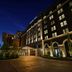 Hotel Vin, Grapevine, Autograph Collection exterior at night with lit windows and arched entrance