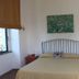 Flegrea House - Casa Rosa bedroom with double bed, bedside tables, wall art, and window in Pozzuoli