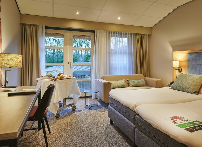 Parkhotel Tjaarda, Oranjewoud: hotel room with twin beds, seating area, and garden-view windows