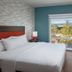 Home2 Suites by Hilton San Jose South guest room with king bed, TV, and window view of San Jose