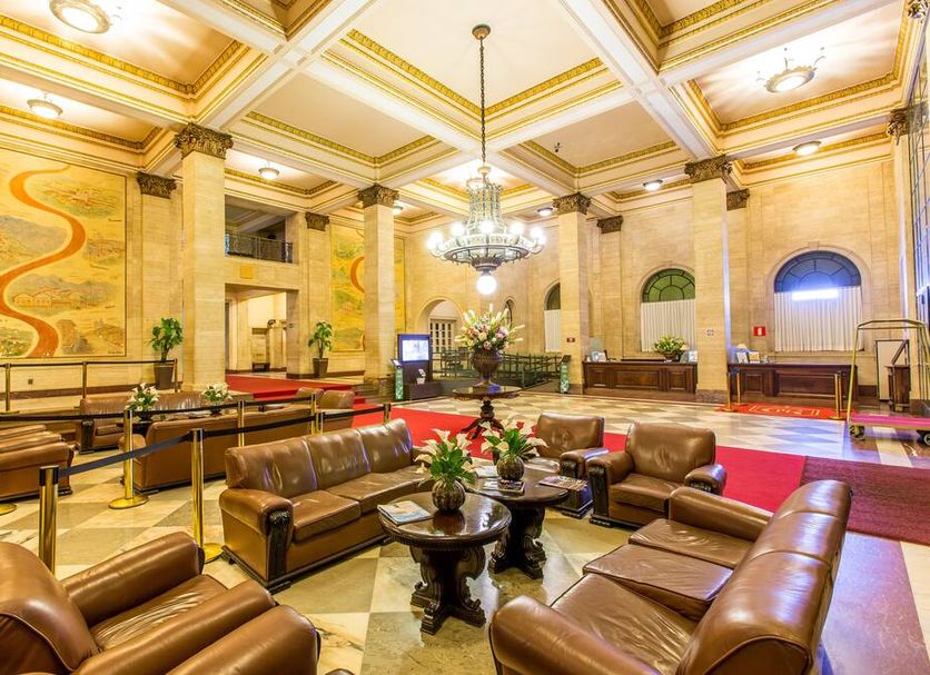 Grande Hotel e Termas de Araxá lobby with leather seating, chandelier, and marble floors in Araxá
