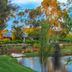 Stonewell Cottages and Vineyards in Tanunda with lakeside lawn, chairs and boat under trees