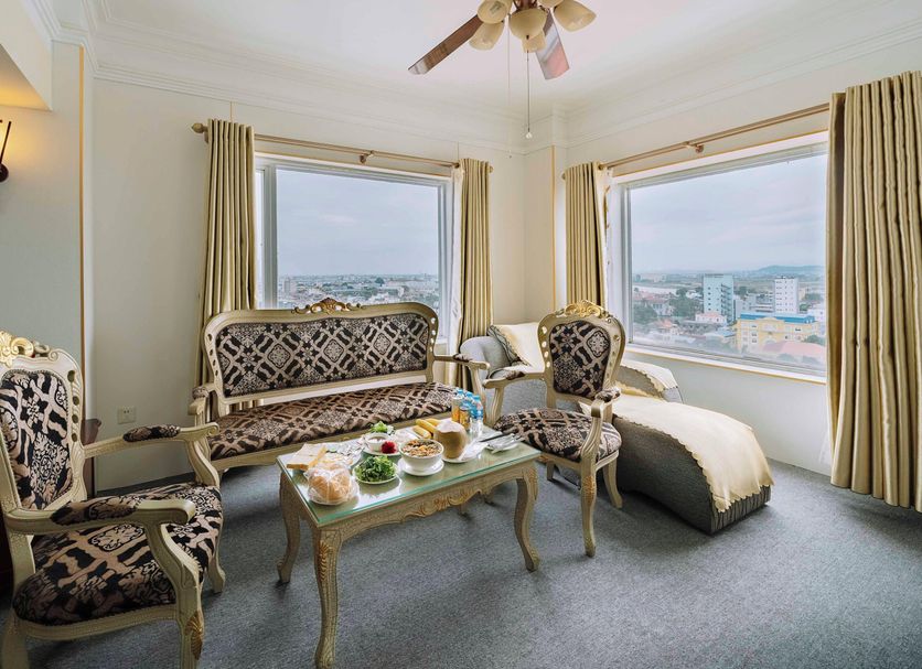 Classic Hoang Long Hotel in Haiphong room with city views, ornate chairs, and a glass coffee table