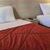 Premiere Classe Strasbourg Ouest room with two single beds and red quilts in Strasbourg