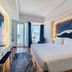 Nha Trang Prince Hotel room with king bed, balcony door, and city view in Nha Trang