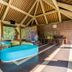 Fullmoon Villa Ubud in Ubud lounge with curved sofas, high wood-beamed ceiling, and garden views